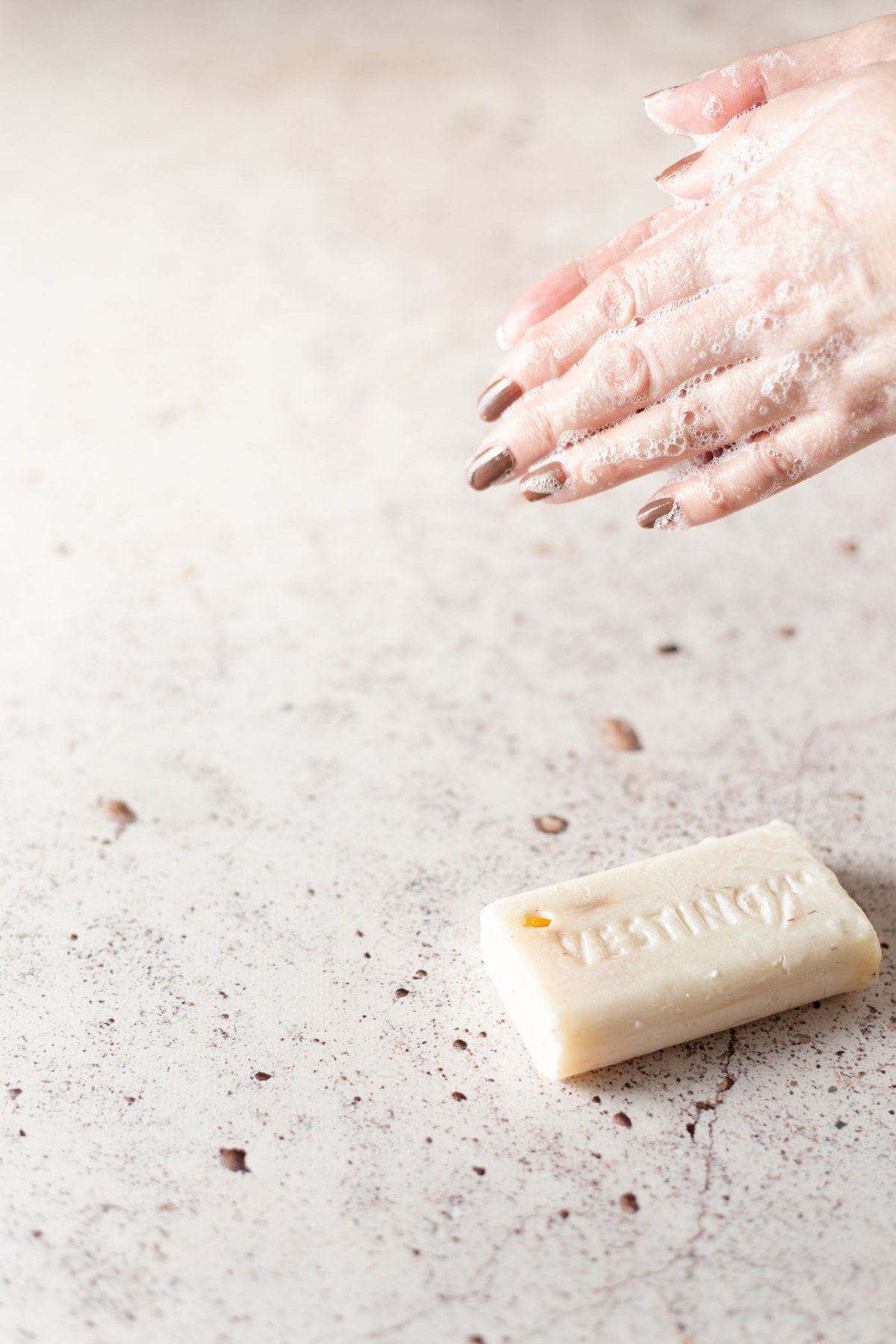 Hands lathering a bar of soap