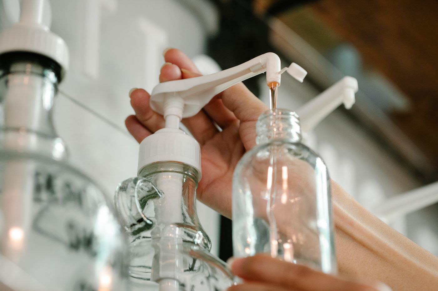 A dispenser fills a small bottle with a cosmetic refill