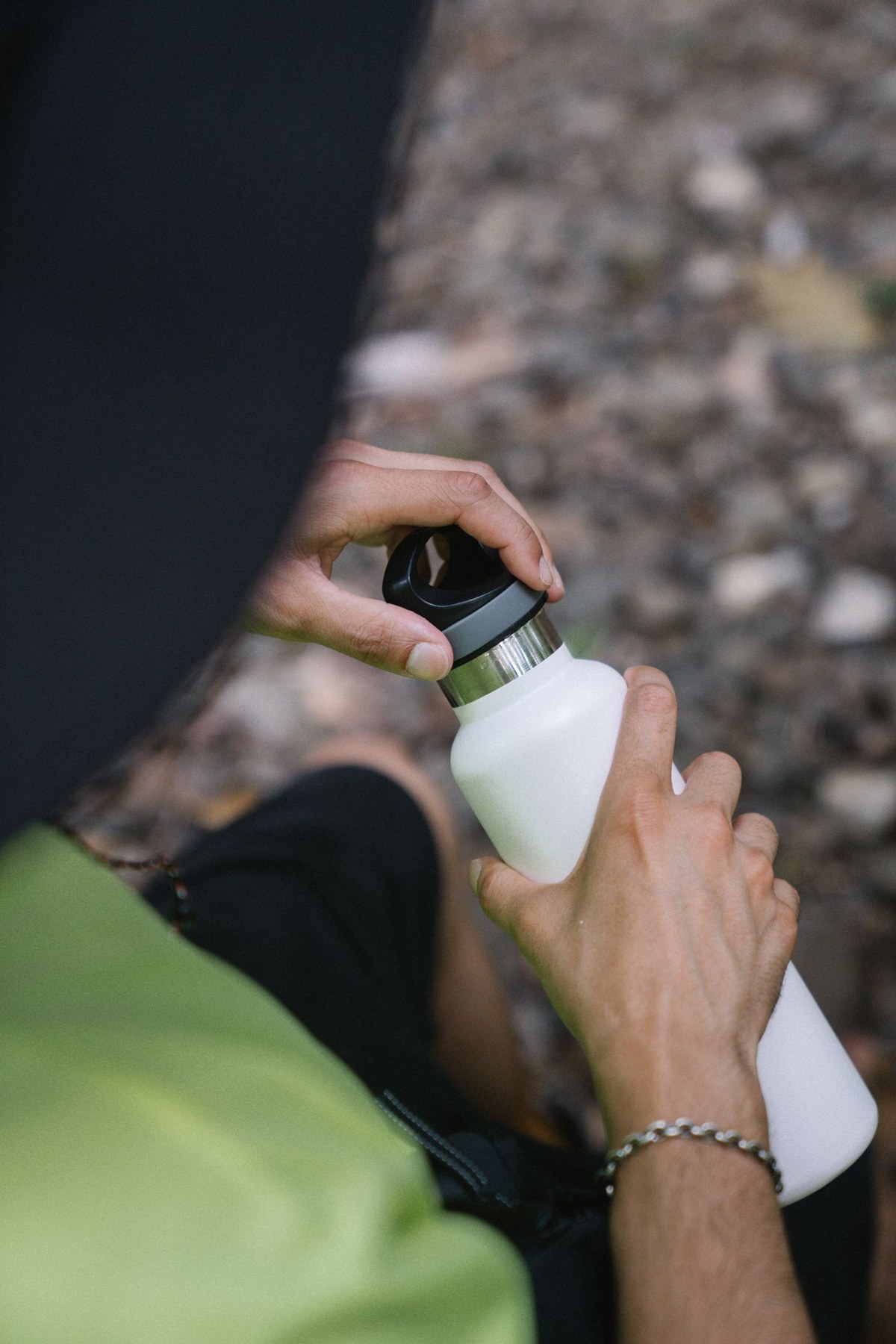 A person unscrews a reusable water bottle lid