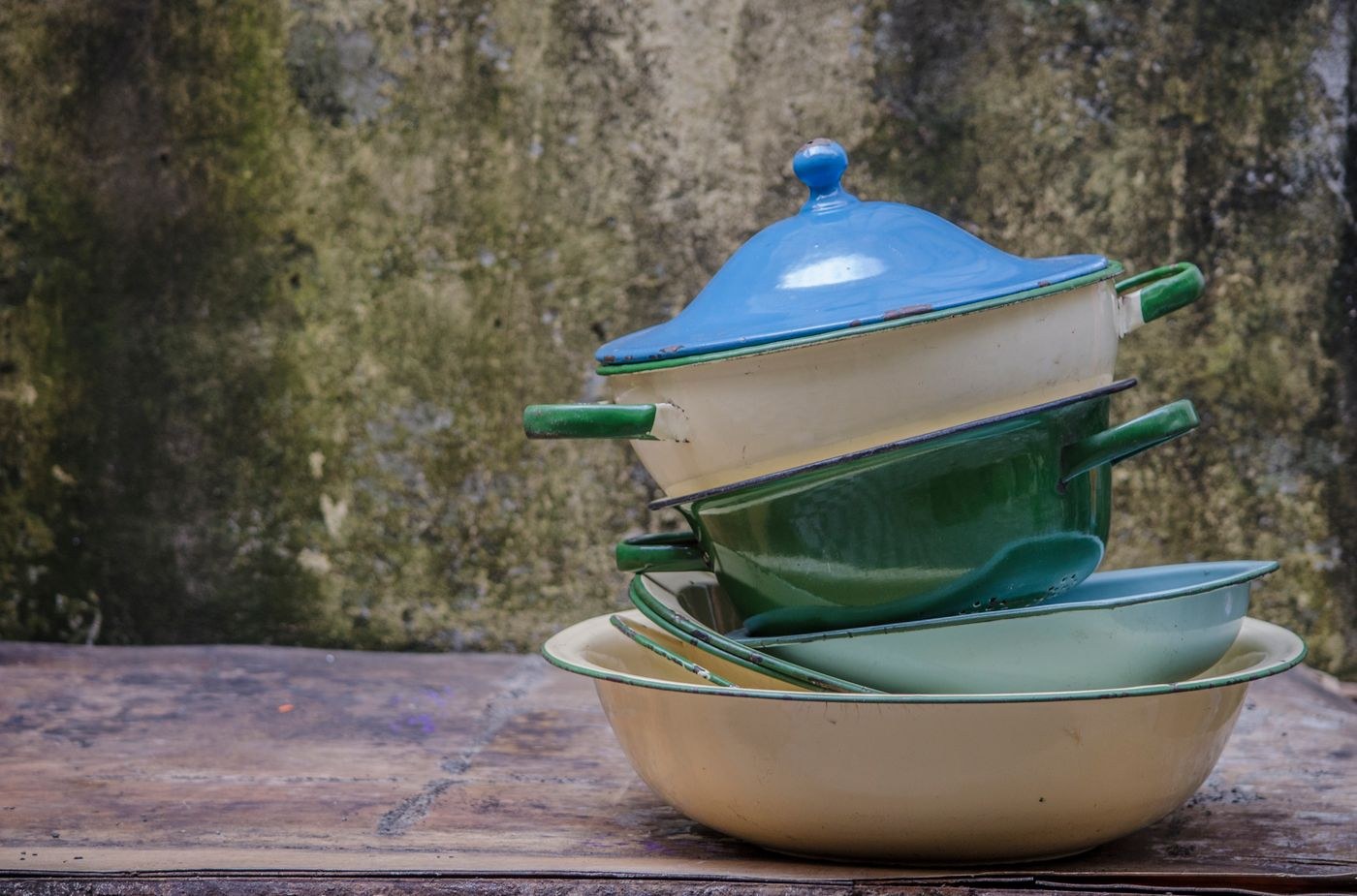 A stack of used enamel pots outdoors