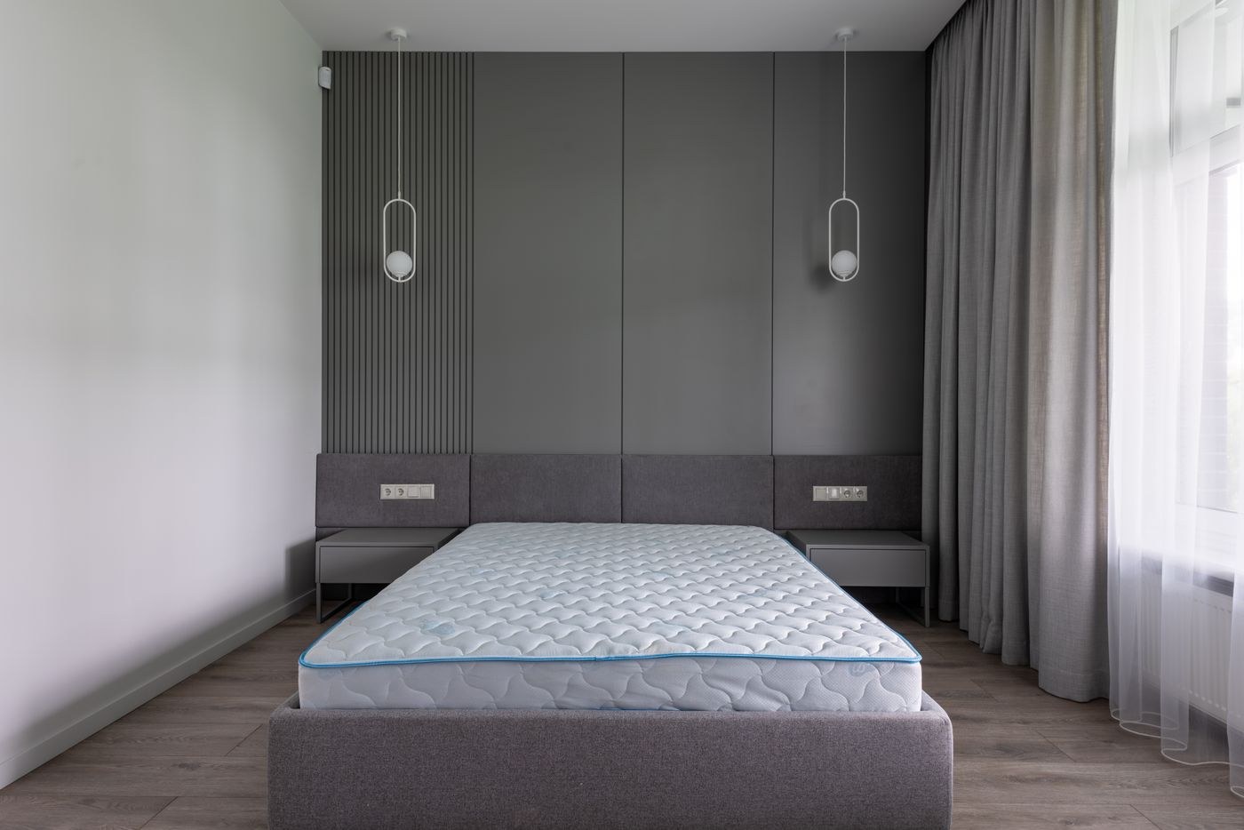 An uncovered mattress on a bed frame