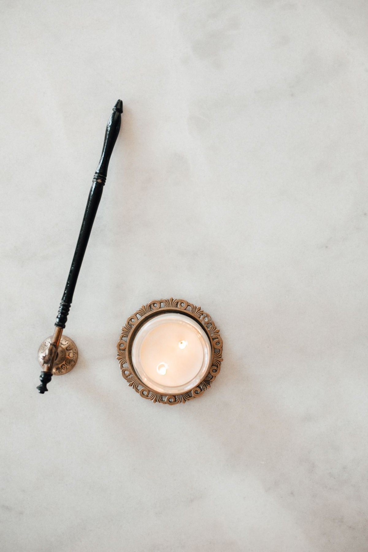 A candle and incense arranged on a marble surface