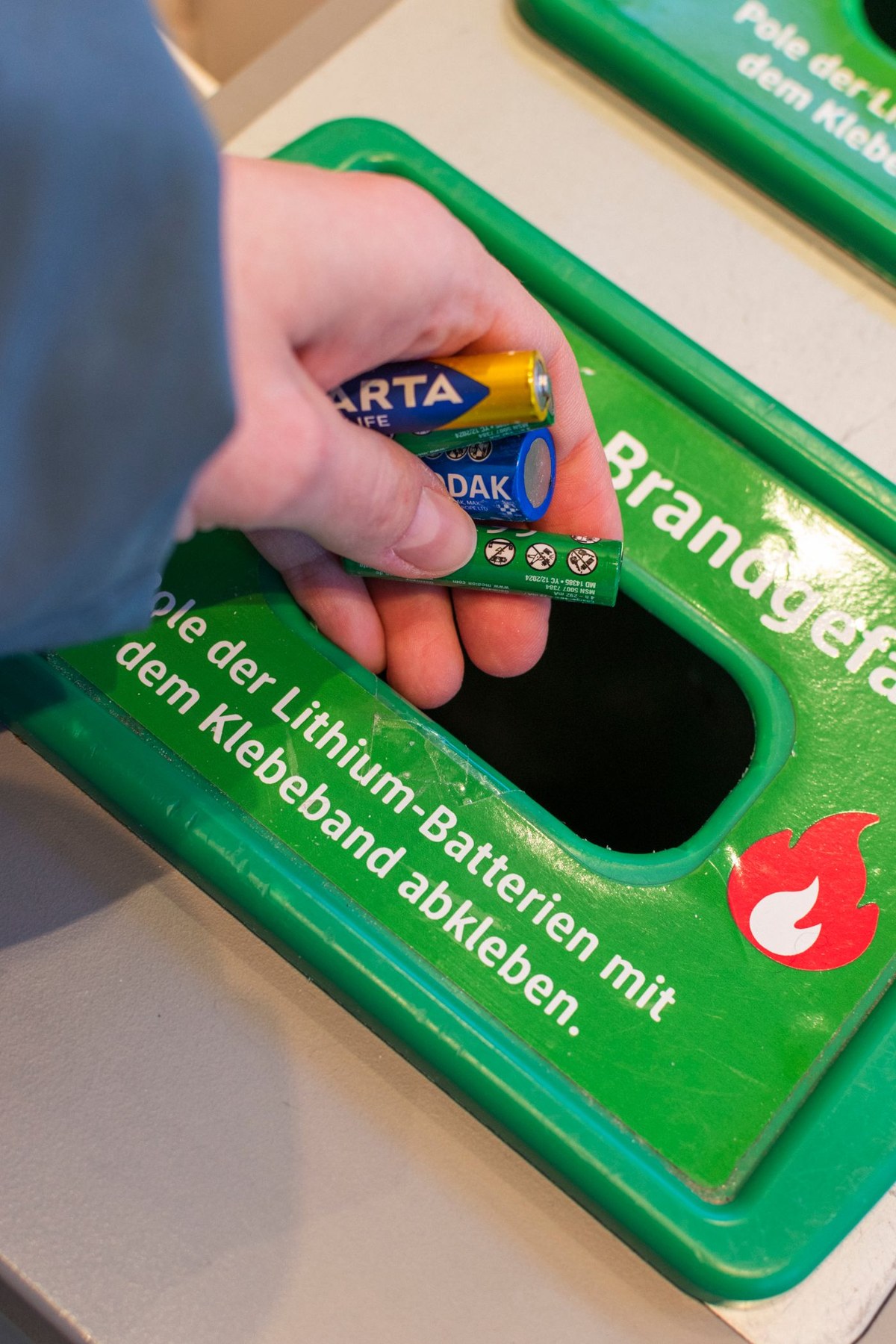 Used household batteries being taken to a collection container